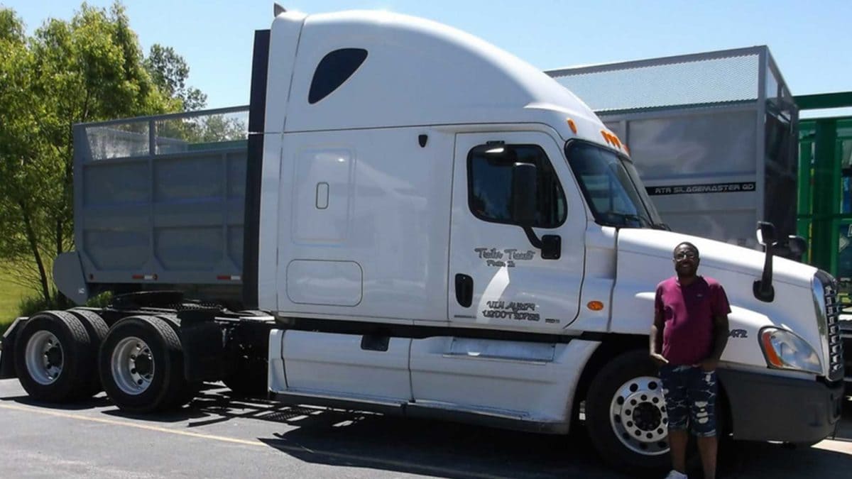 Trailer Transit Inc. | A man standing in front of a white semi truck.