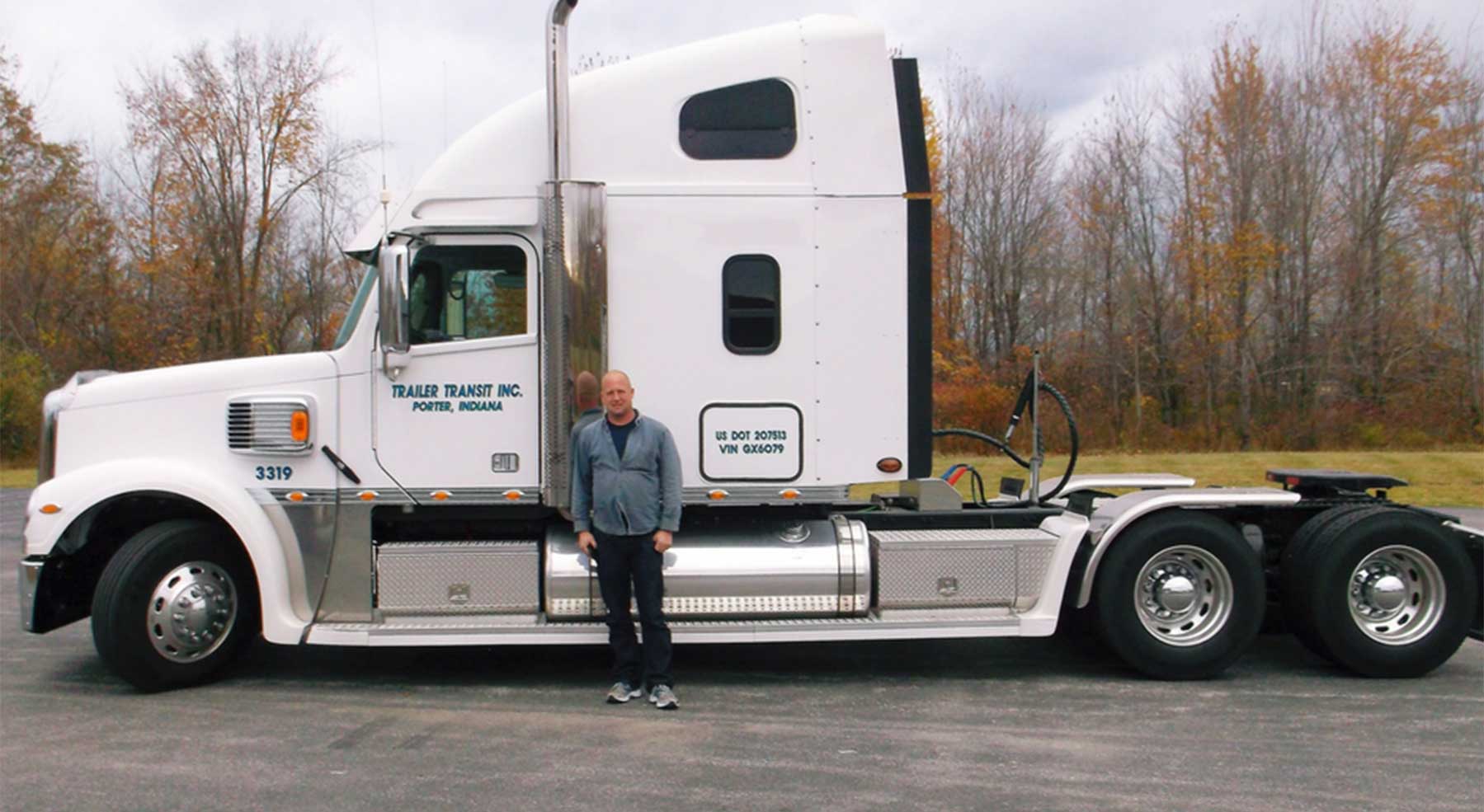 Trailer Transit Inc. | A man standing in front of a white semi truck.