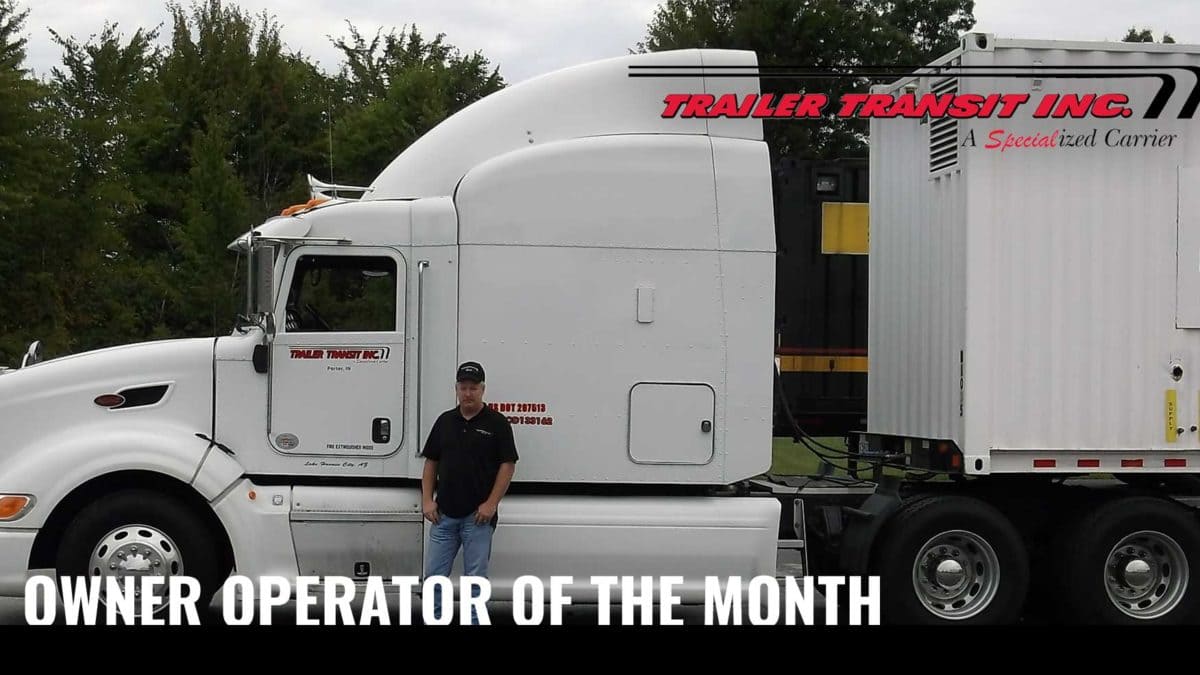 Trailer Transit Inc. | A man standing in front of a semi truck with the words owner operator of the month.