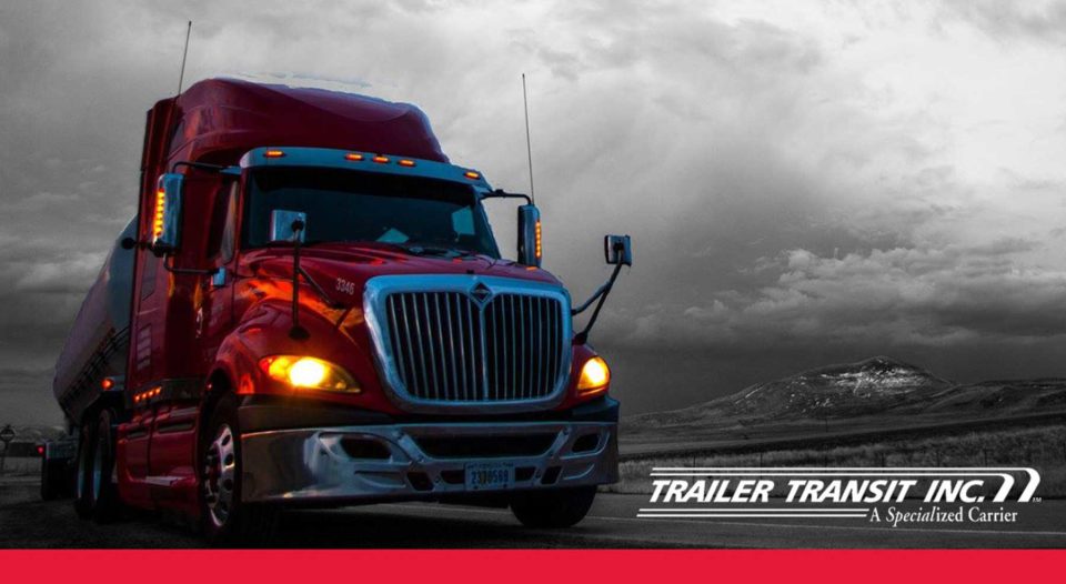 Trailer Transit Inc. logo on photo of red truck hauling on the road