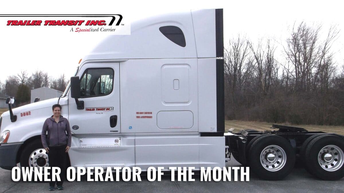 Trailer Transit Inc. | A woman standing in front of a white truck with the words owner operator of the month.