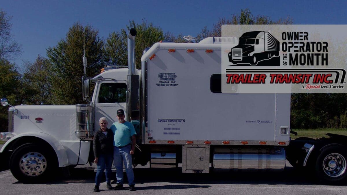 Trailer Transit Inc. | Two people standing in front of a white semi truck.