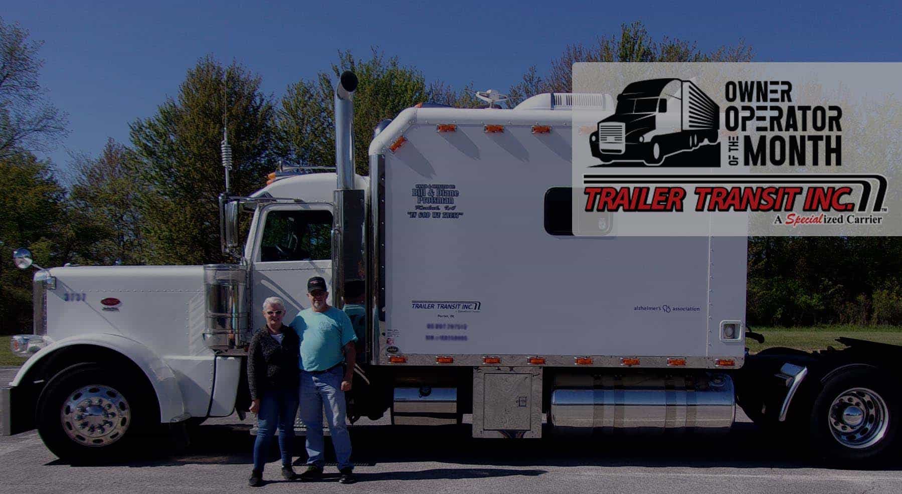 Trailer Transit Inc. | Two people standing in front of a white semi truck.