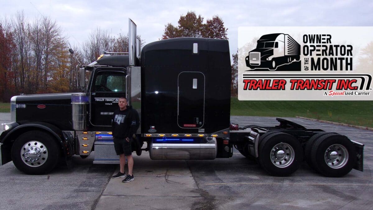 Trailer Transit Inc. | February 2022 Owner Operator of the Month standing in front of a black semi truck.