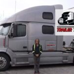 Trailer Transit Inc. | A woman standing in front of a silver semi truck.