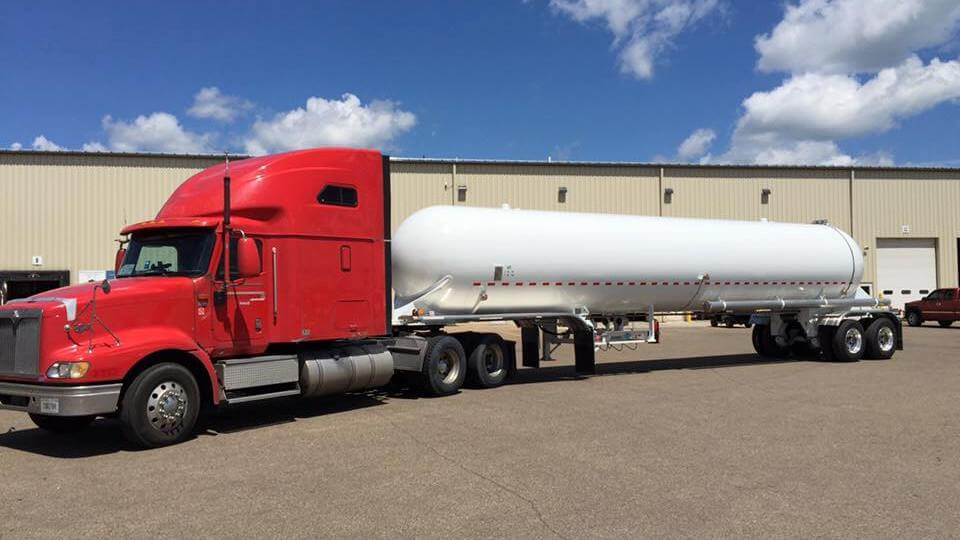 Red Trailer Transit, Inc truck hauling a white tanker