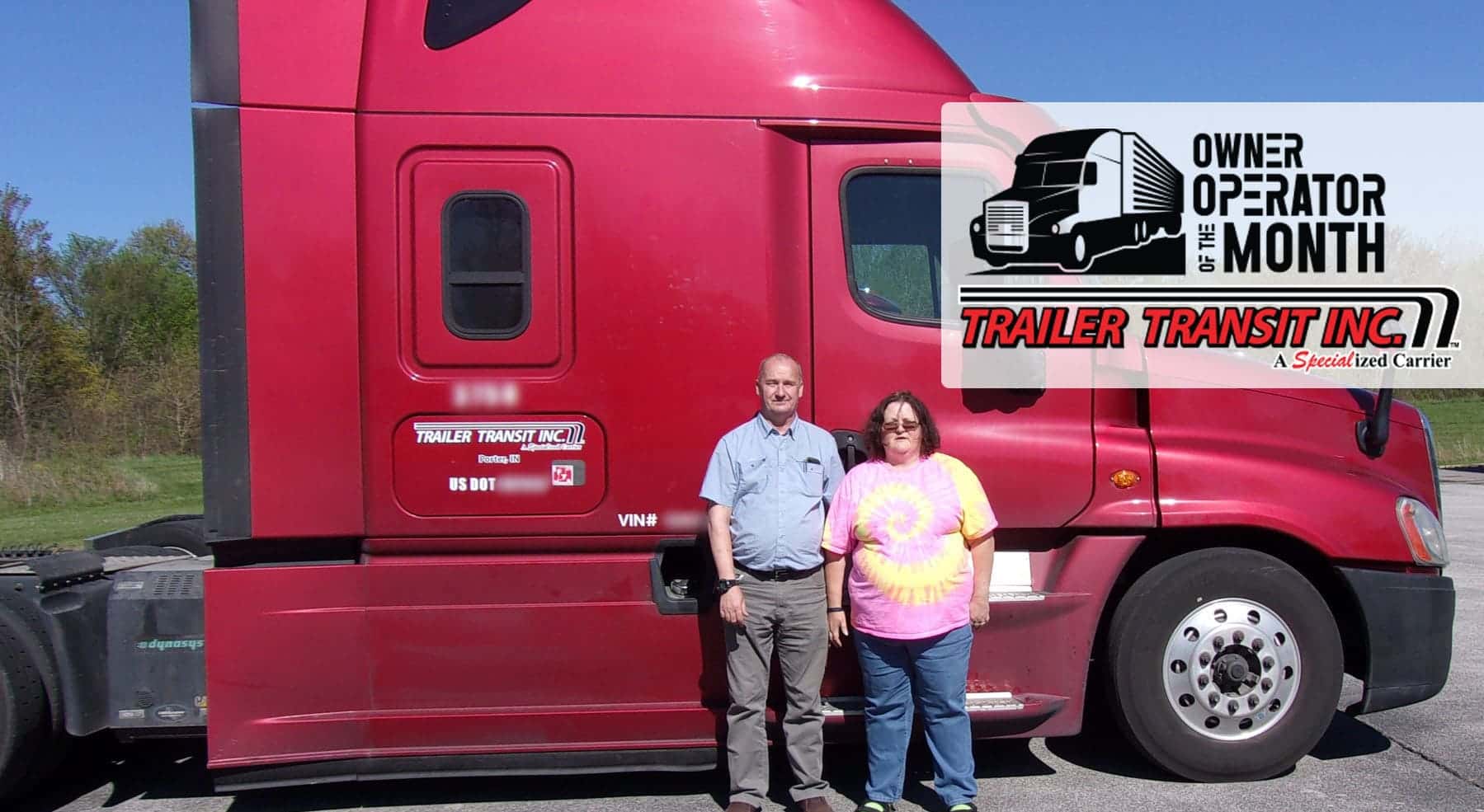 Trailer Transit Inc. | Two people standing in front of a red semi truck.