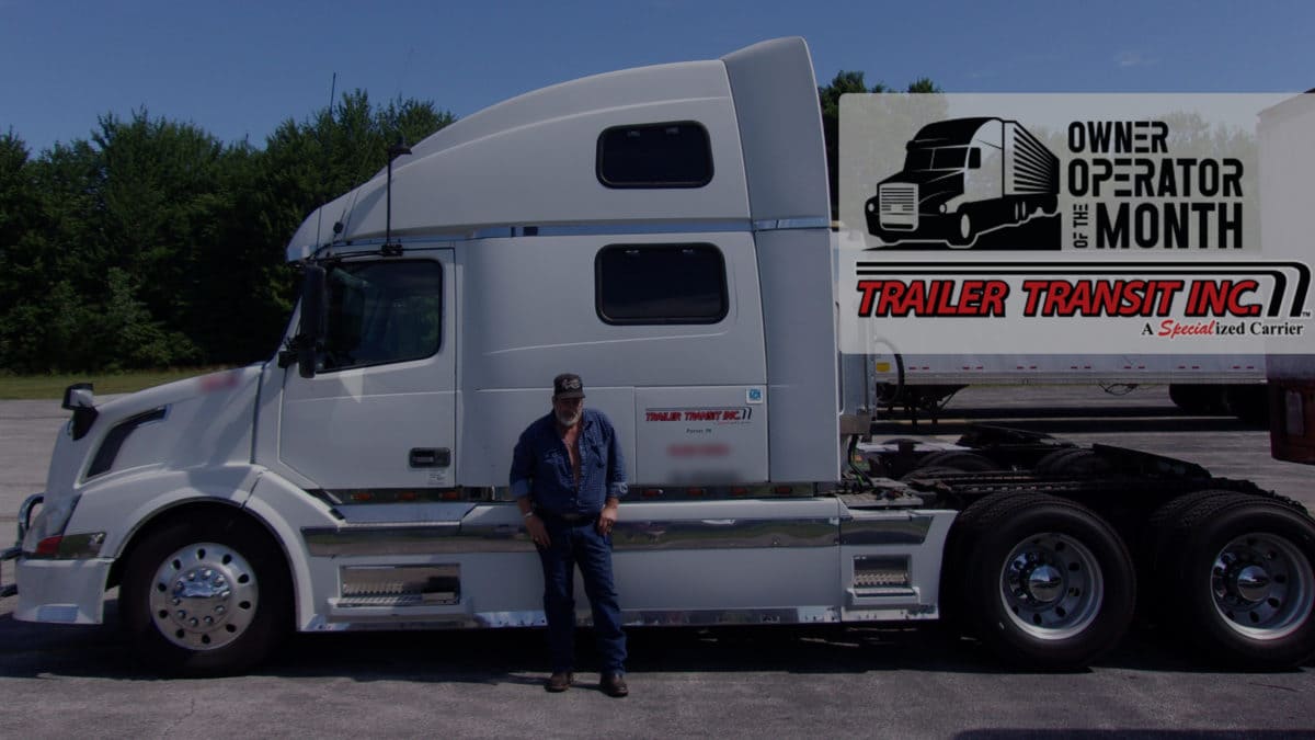 Trailer Transit Inc. | A man standing in front of a white semi truck.