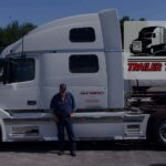 Trailer Transit Inc. | A man standing in front of a white semi truck.