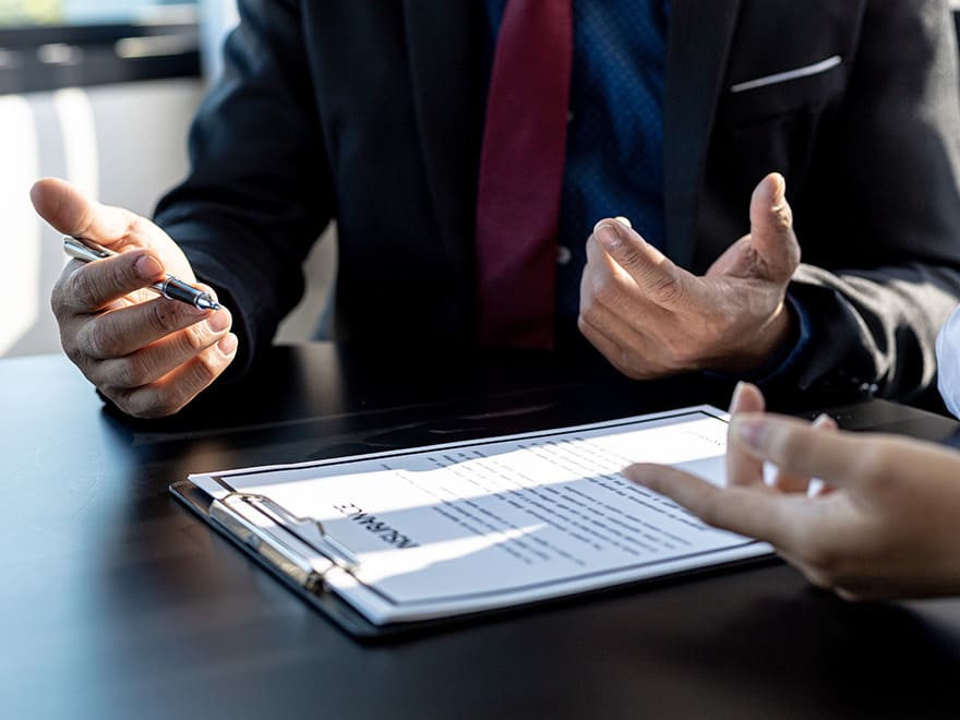 Trailer Transit Inc. | Two people sitting at a desk signing a document discussing the benefits of Dash Cams for Owner Operators/Power Only Drivers.