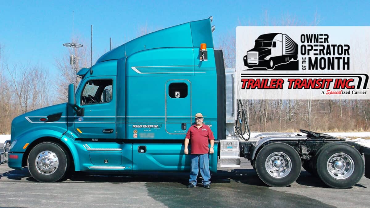 Trailer Transit Inc. | A man standing in front of a blue semi truck.