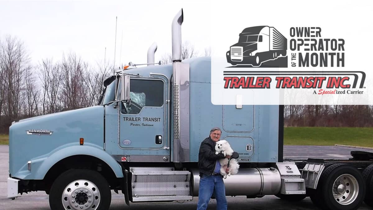 Trailer Transit Inc. | A man proudly standing next to a semi truck, showcasing his achievement as the Owner Operator of the Month.