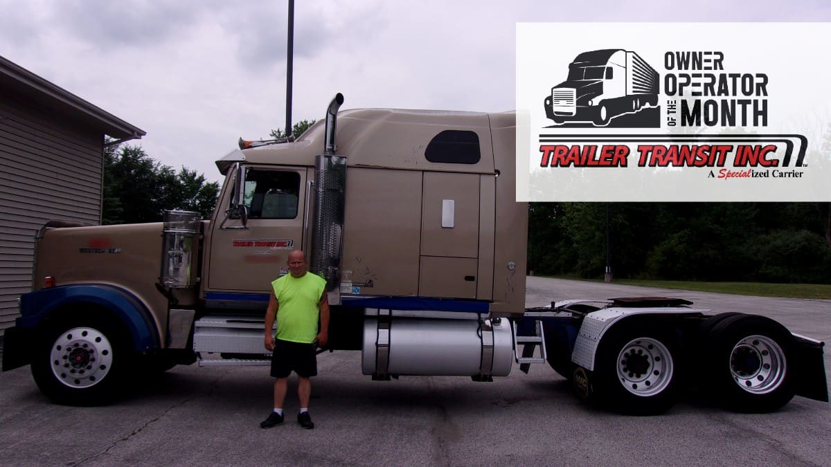 Trailer Transit Inc. | A man standing in front of a semi truck, recognized as the Owner Operator of the Month.