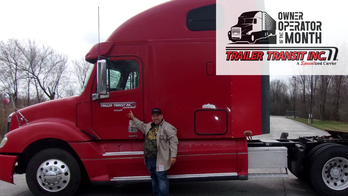 Trailer Transit Inc. | The Owner Operator of the Month proudly stands next to a red semi truck.