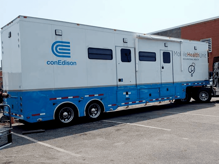 Trailer Transit Inc. | A blue and white Mobile Health Unit truck parked in front of a building.