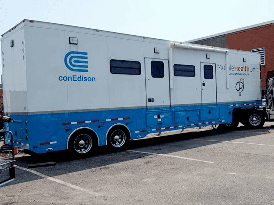 TT-BlogImage-0923-ArticleImages-3 Trailer Transit Inc. | A blue and white Mobile Health Unit truck parked in front of a building.