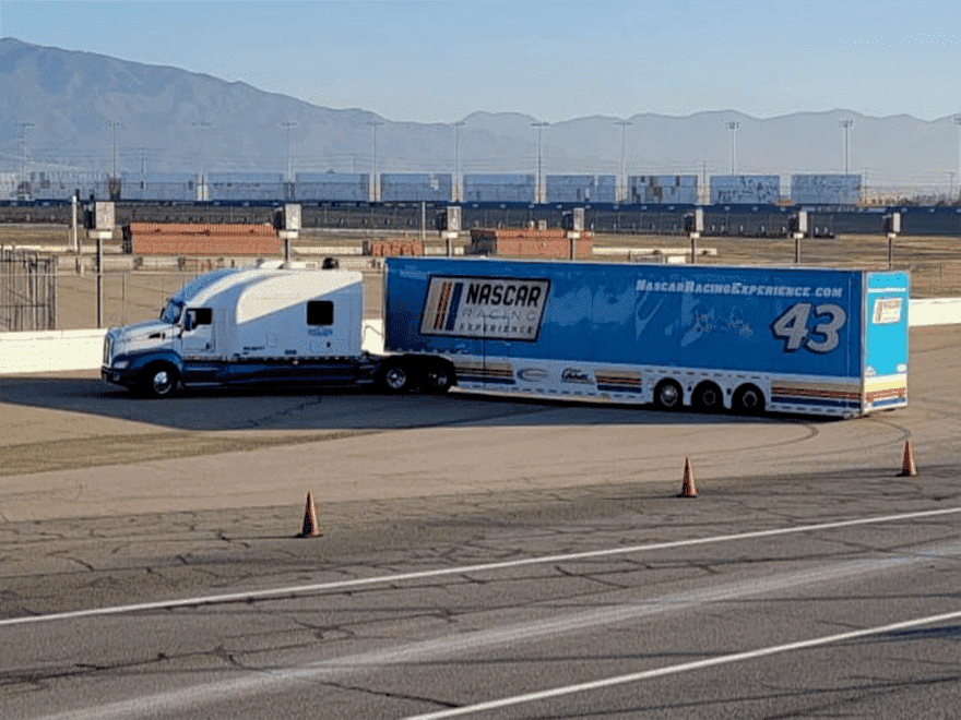 TT-BlogImage-0923-ArticleImages-4 Trailer Transit Inc. | A semi truck is parked on a track with mountains in the background.
