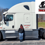 Trailer Transit Inc. | The Owner Operator of the Month proudly poses next to her white semi truck.