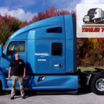 Trailer Transit Inc. | Owner Operator Dan, standing in front his blue Kenworth truck.