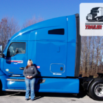 Trailer Transit Inc. | Owner operator Michelle standing by her blue semi-truck.