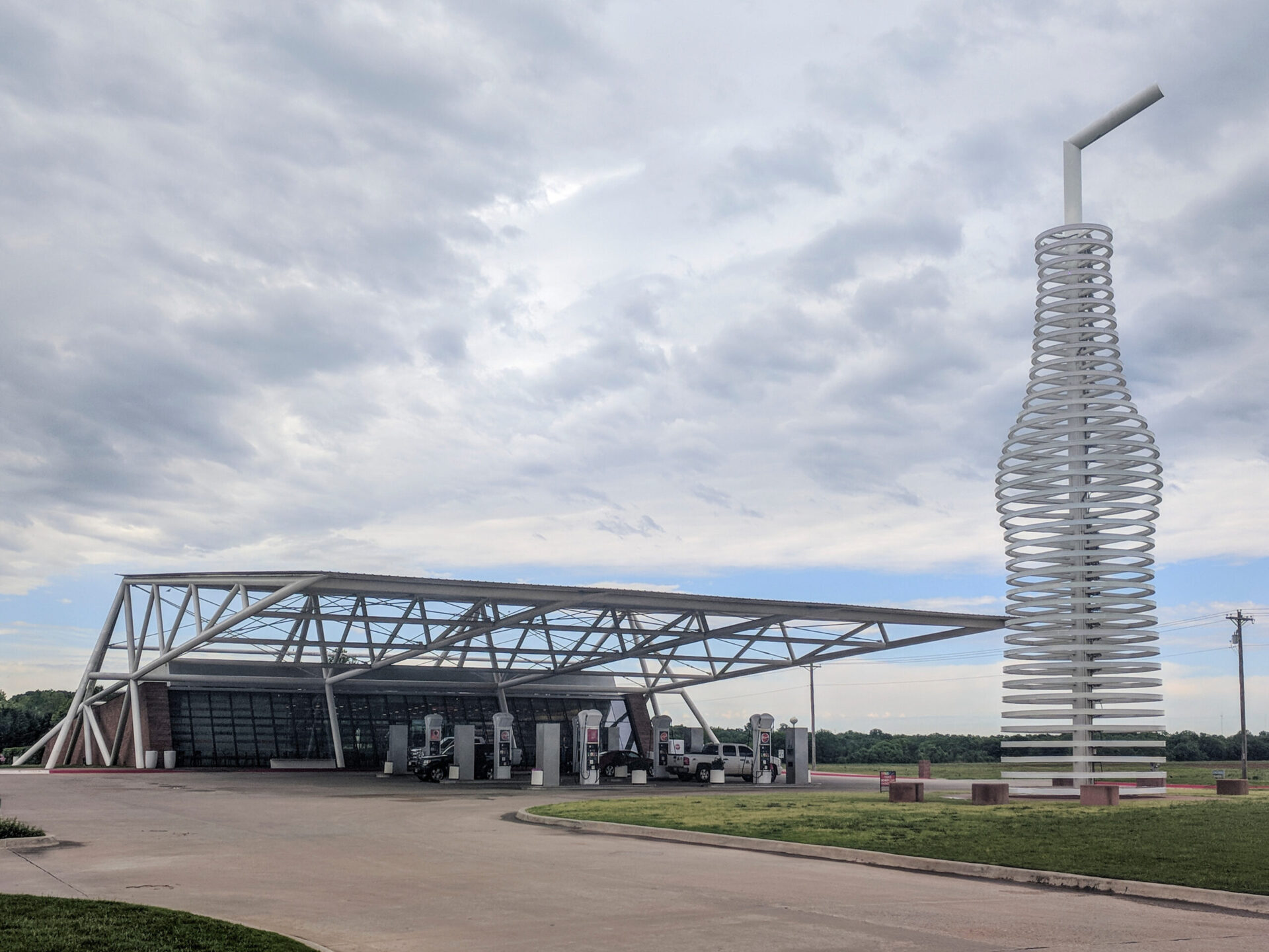 Trailer Transit Inc. | A modern gas station with a large roof structure and a tall bottle-shaped sculpture, Pops 66 Soda Ranch