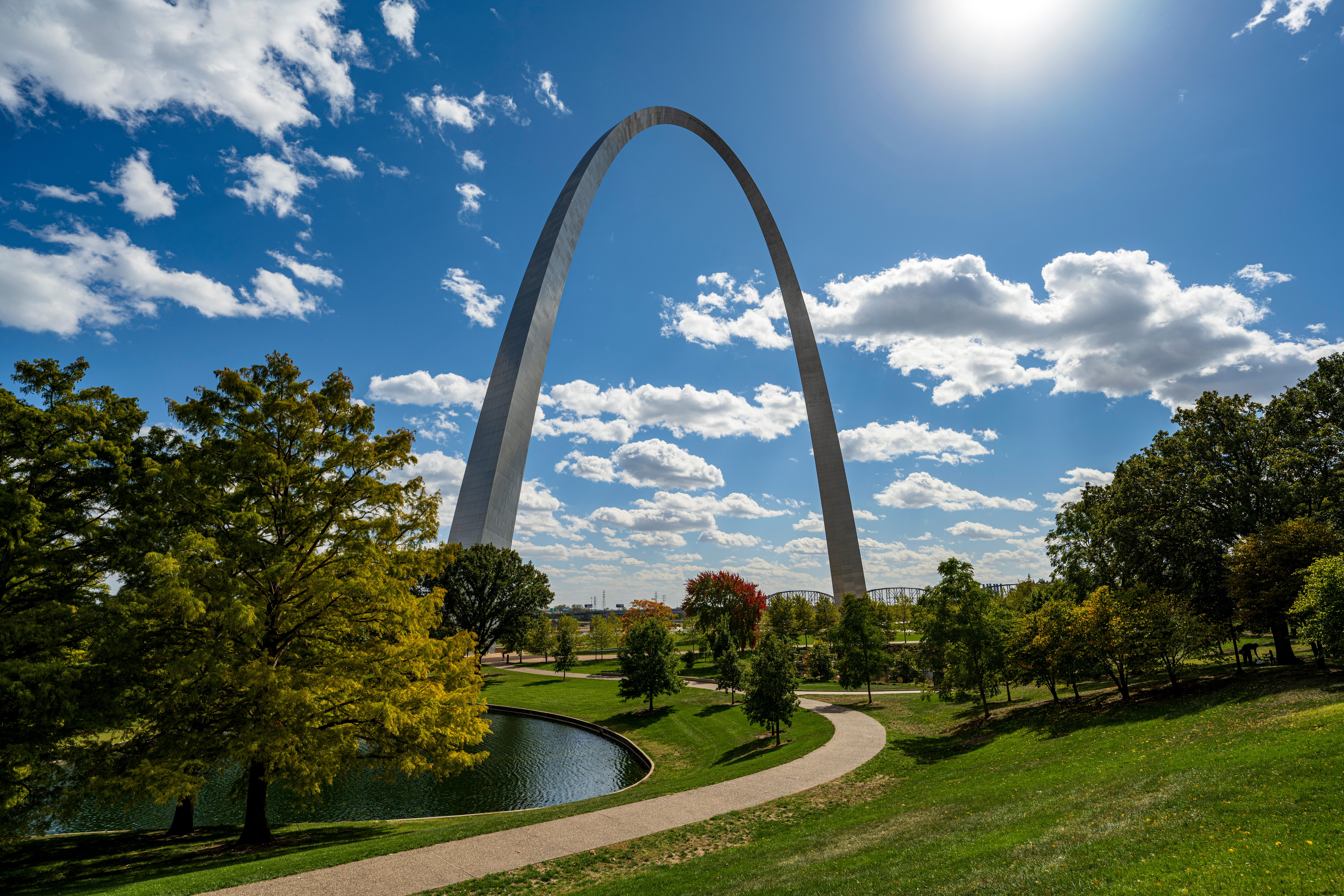 Trailer Transit Inc. | photo of the Gateway Arch in St. Louis, MO with blue sky and clouds, trees and a pond