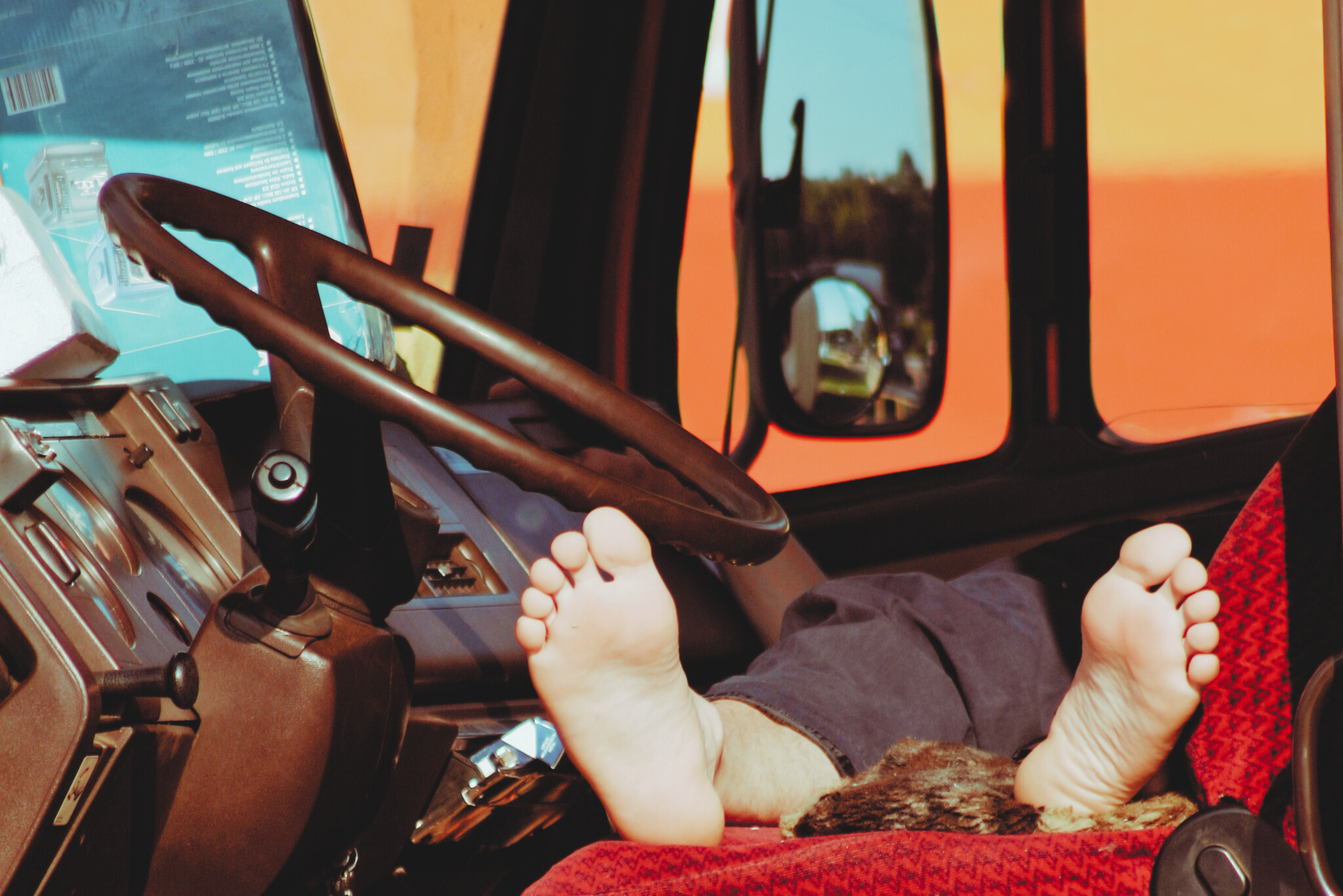 6 Trailer Transit, Inc | feet of man sleeping in the cab of his semi truck