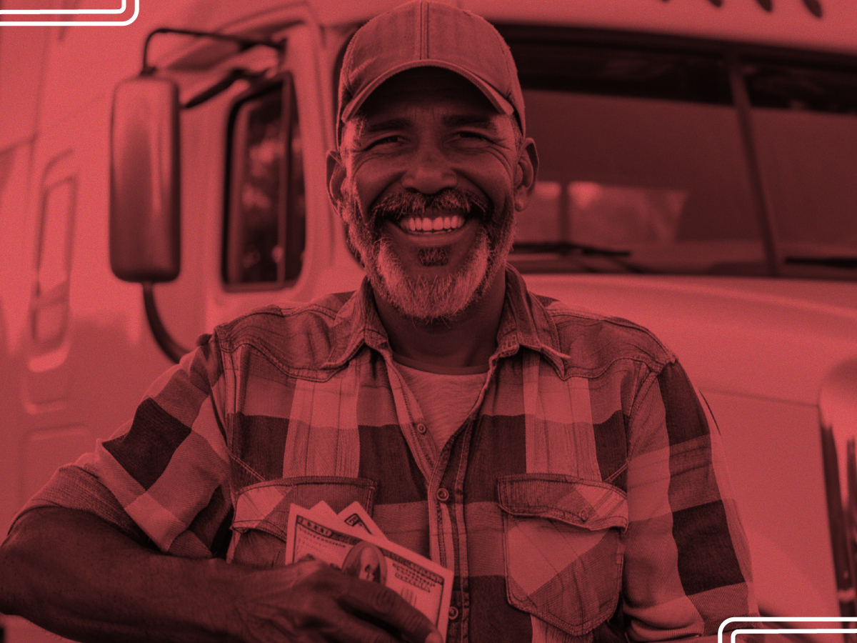 TT Blog0125_Financial Necessity_A Trailer Transit Inc. | Man in a plaid shirt and cap, grinning in front of his truck, clutches cash to show that being an owner operator truck driver has helped his finances.
