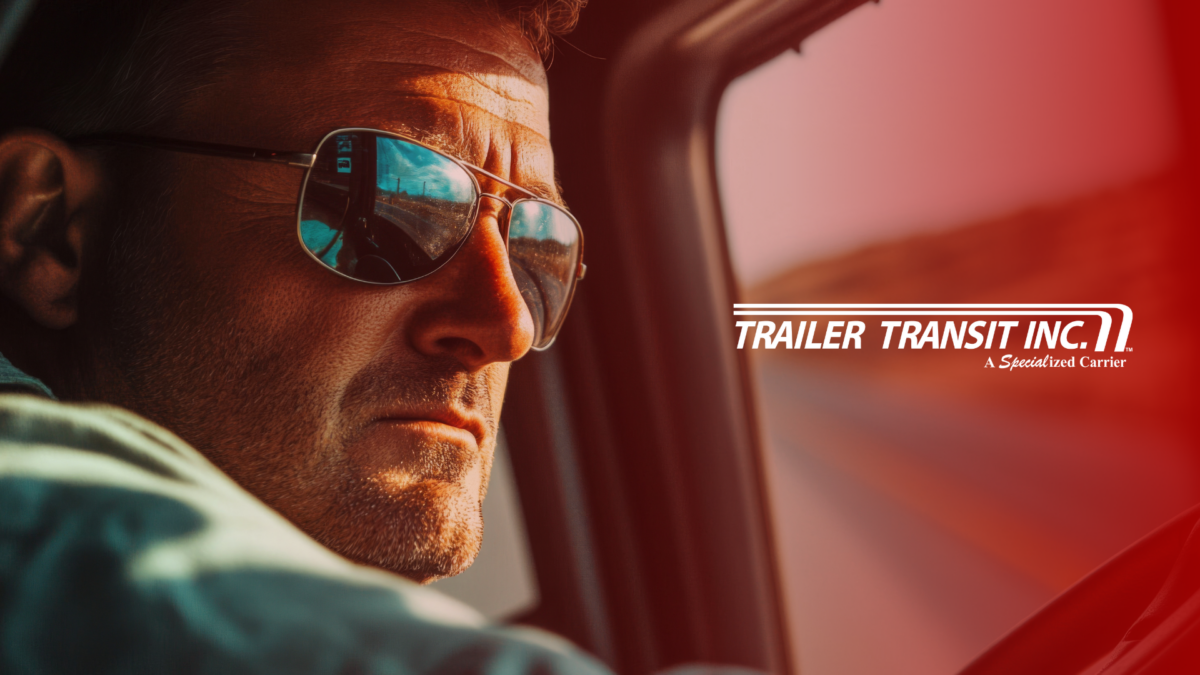 Trailer Transit Inc. | An owner operator wearing sunglasses in the cab of his rig; face reflected in the window. The logo "Trailer Transit Inc. A Specialized Power-Only Trucking Carrier" is displayed on the right side.