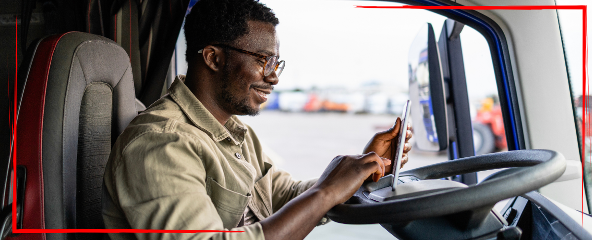 Trailer Transit Inc. | A power only driver sits in the cab of his rig with a tablet, possibly working or enjoying a video call with family back home.