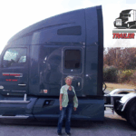 Trailer Transit Inc. | Owner Operator Brenda stands in front of her semi-truck. A logo in the top right corner reads "Owner Operator of the Month, Trailer Transit Inc," celebrating outstanding Owner Operator achievements.