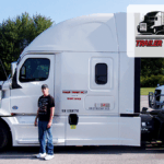 Trailer Transit Inc. | Owner Operator of the Month, Scott, stands next to his white semi-truck in a parking lot. A badge in the image proudly displays "Owner Operator of the Month, Trailer Transit Inc.