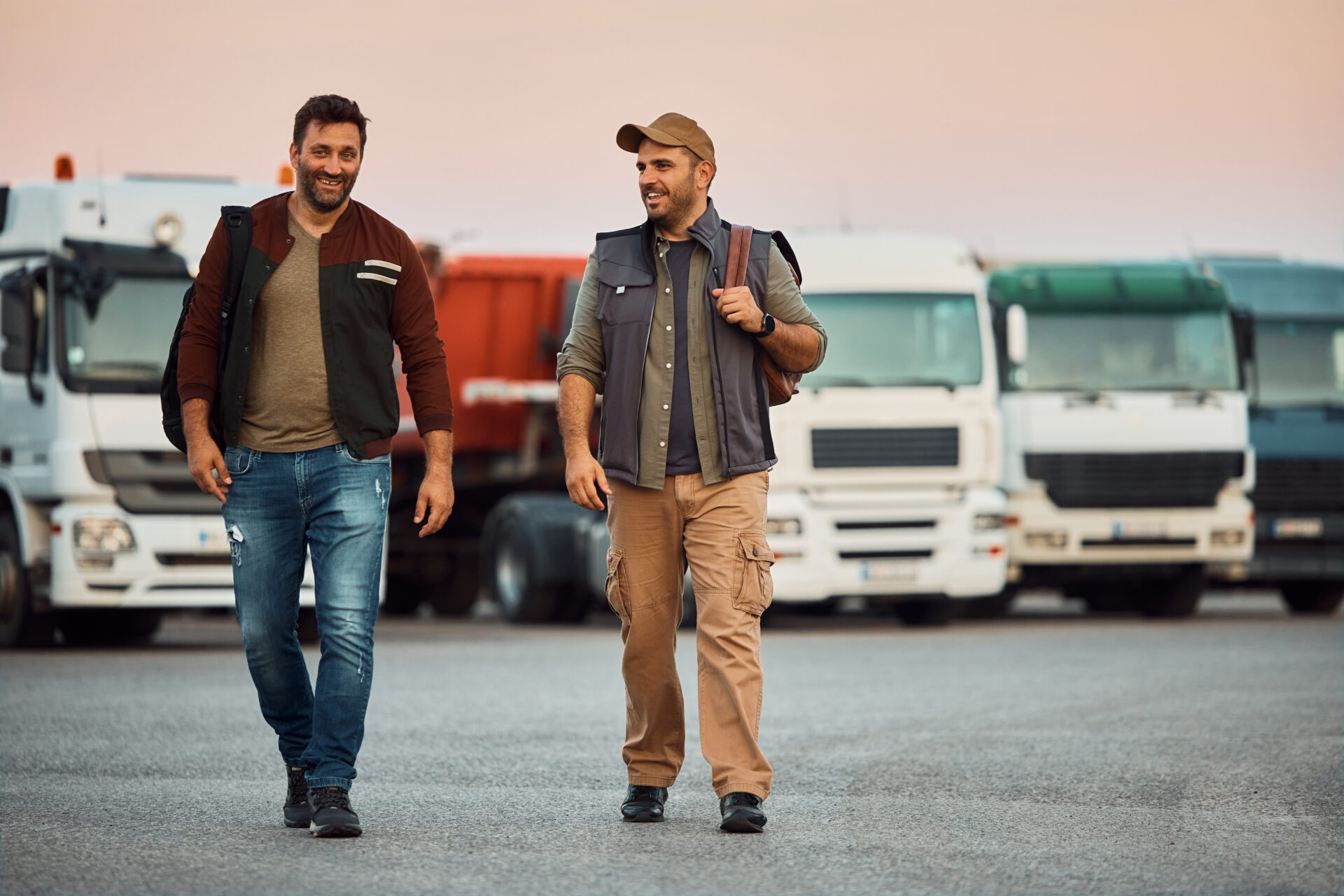 Trailer Transit Inc. | And owner operator walks through a parking lot full of semi trucks with a friend who joined him for a haul.