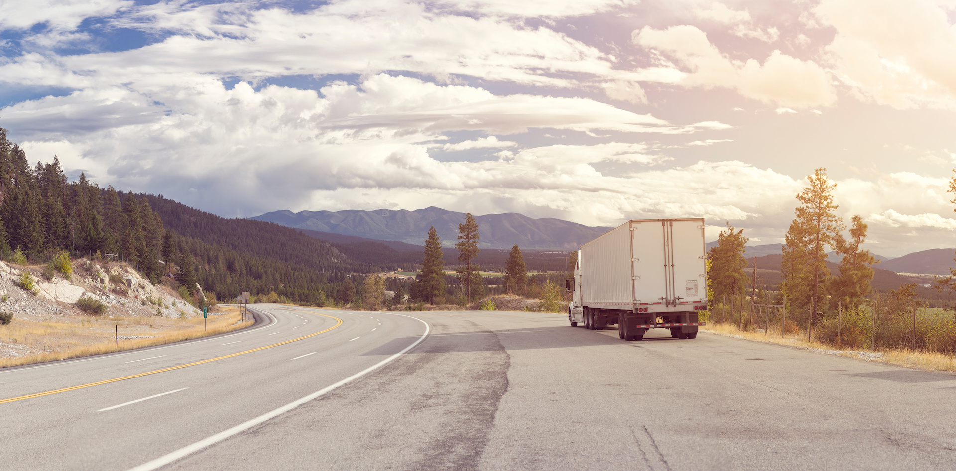 Panorama of beautiful nature and a mountain highway with a semi truck on the road shoulder