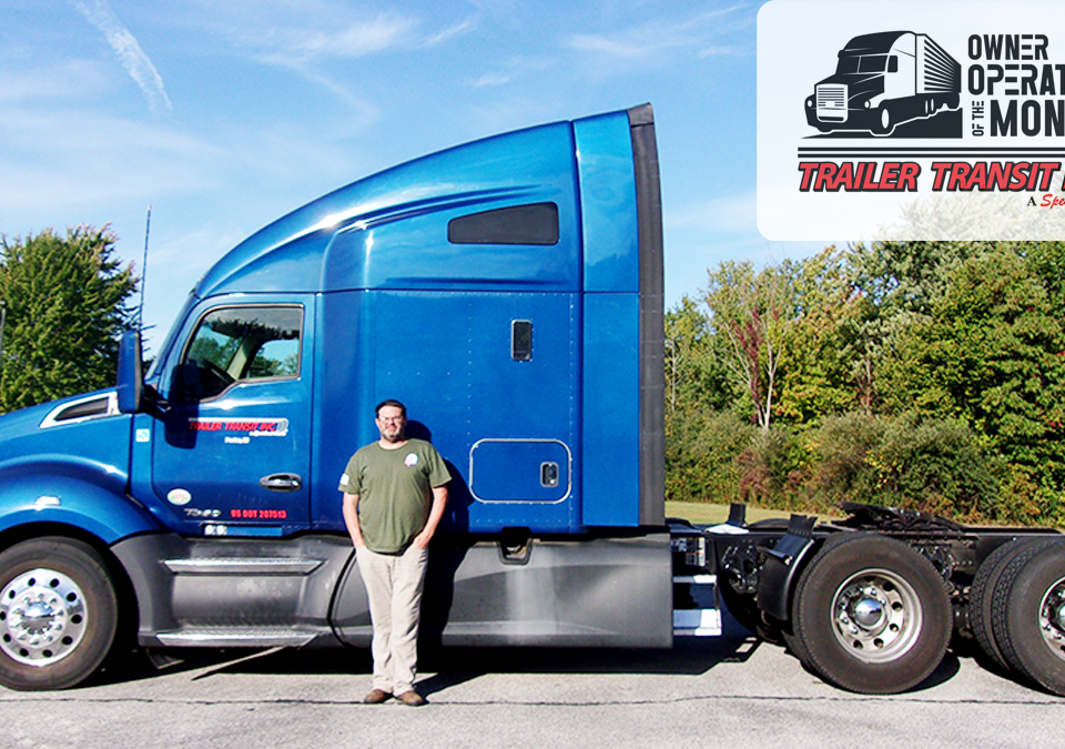 Trailer Transit, Inc. | Power Only driver, O.J. stands in front of his blue semi truck as the owner operator of the month of April. There are green trees in the background and the owner operator of the month logo overlay at the top.